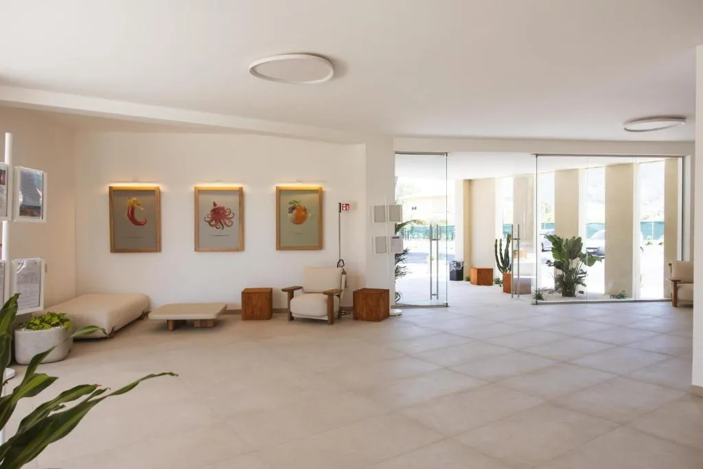 Hall luminosa del resort con poltrone, quadri decorativi e vetrate