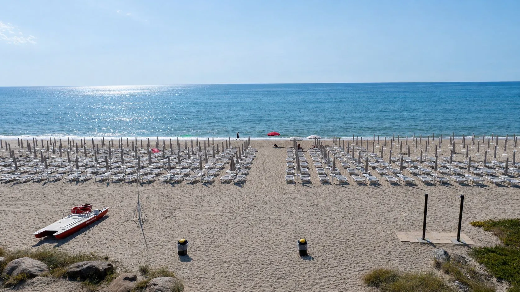 Spiaggia attrezzata con file di lettini e ombrelloni davanti al mare