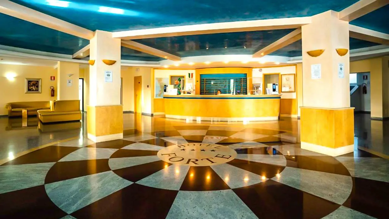 Reception dell'Hotel Forte con pavimento decorato e soffitto blu