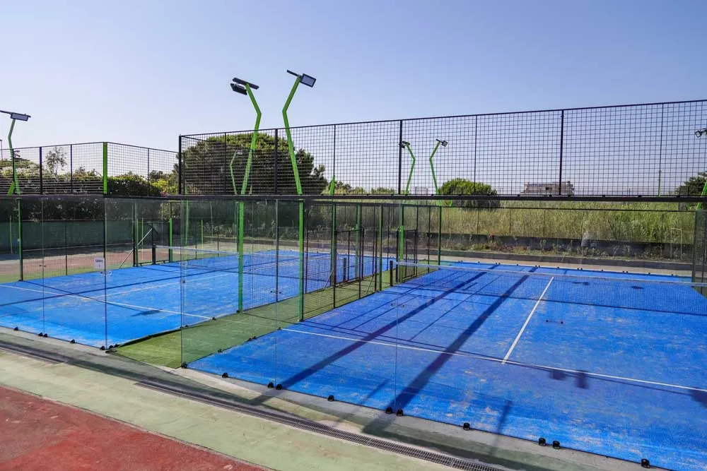 Campi da padel con superficie blu e recinzione in vetro