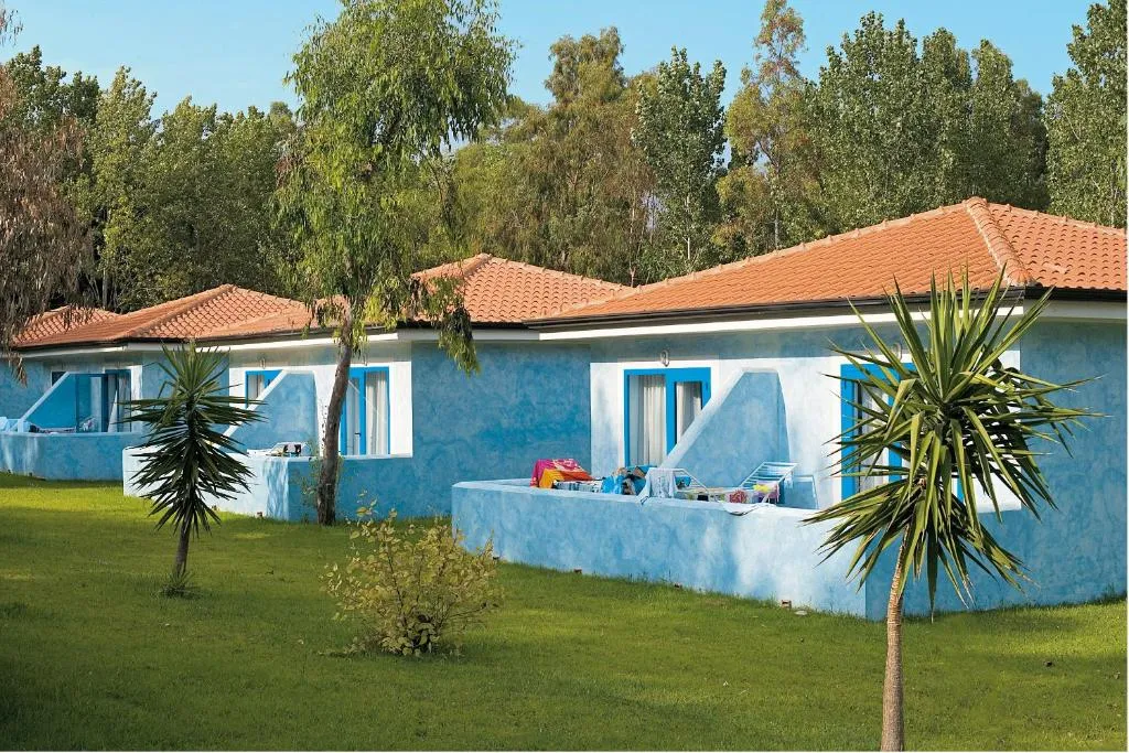 File di casette azzurre del resort con tetti in tegole immerse nel verde