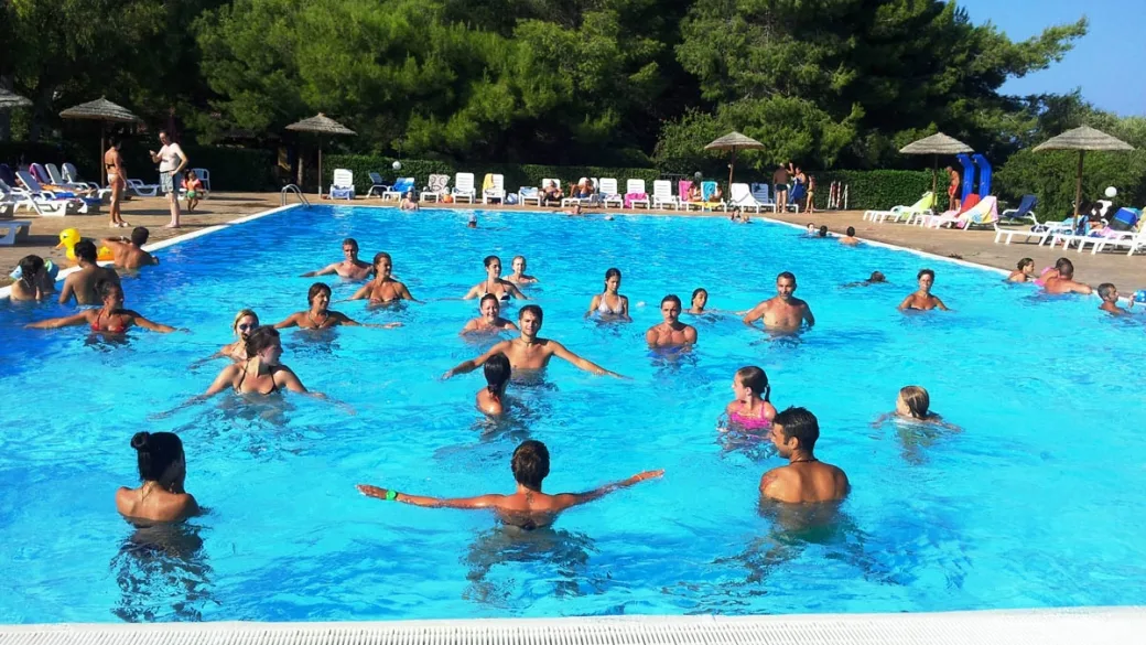 Attività di acquagym in piscina con numerosi ospiti in acqua