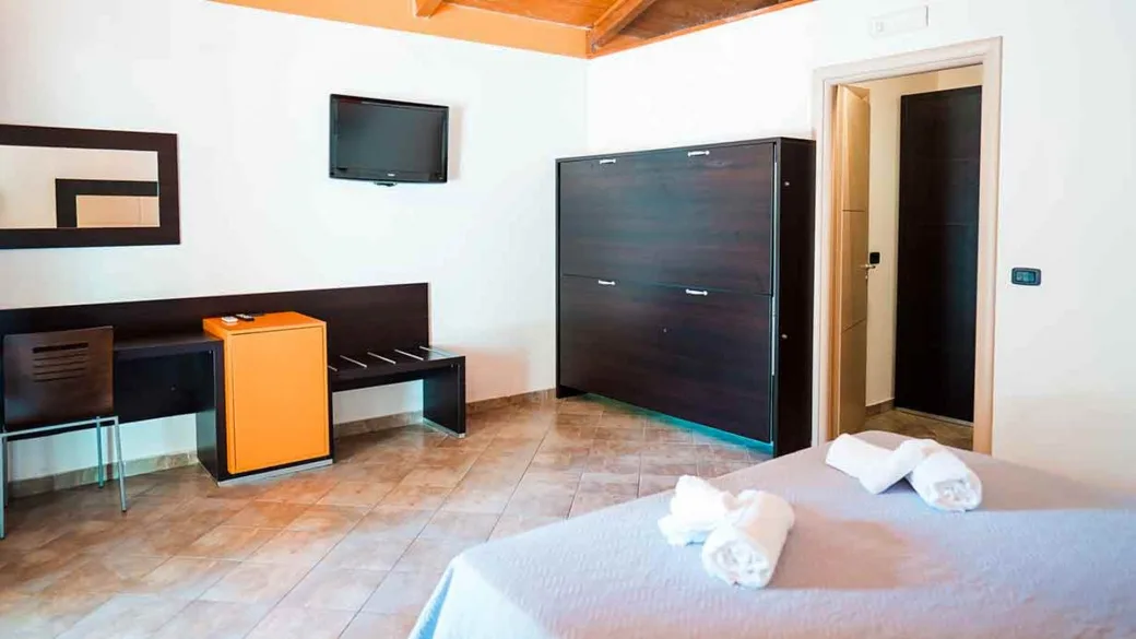 Camera con scrivania, TV a parete e armadio in ambiente moderno