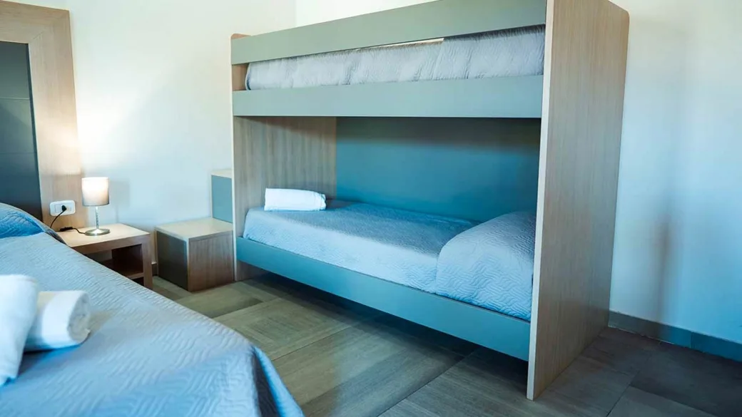 Camera con letto a castello e letto matrimoniale in tonalità azzurre
