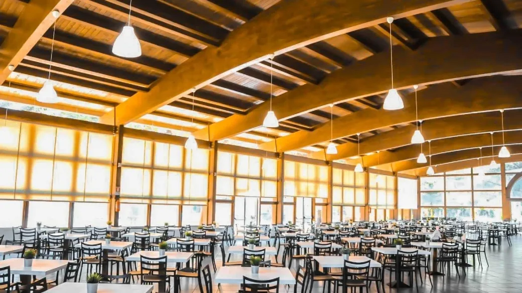 Ampia sala ristorante con soffitto in legno e numerosi tavoli