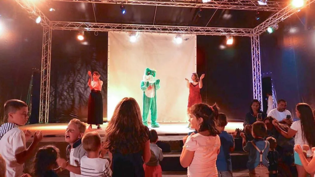 Spettacolo serale di animazione con mascotte su palco e bambini