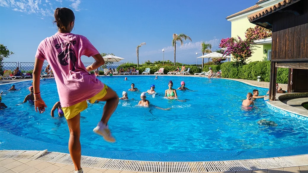 Animazione in piscina con acquagym e partecipanti in acqua