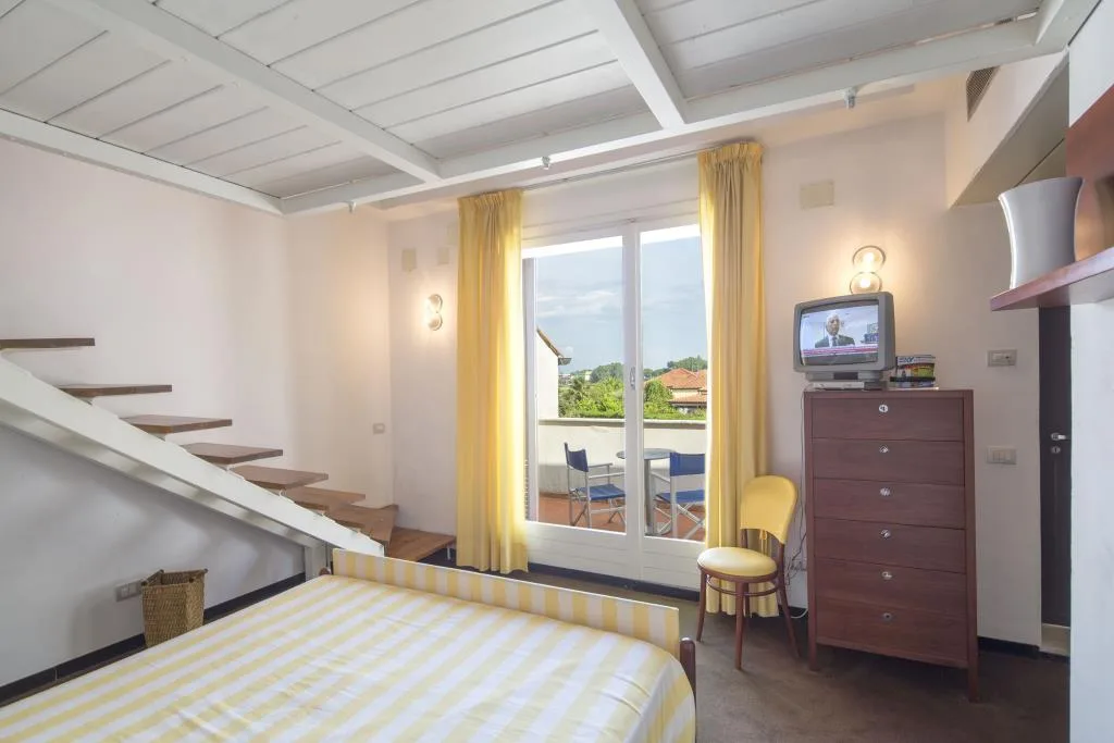 Camera con soppalco e scala in legno, letto matrimoniale, cassettiera e balcone panoramico