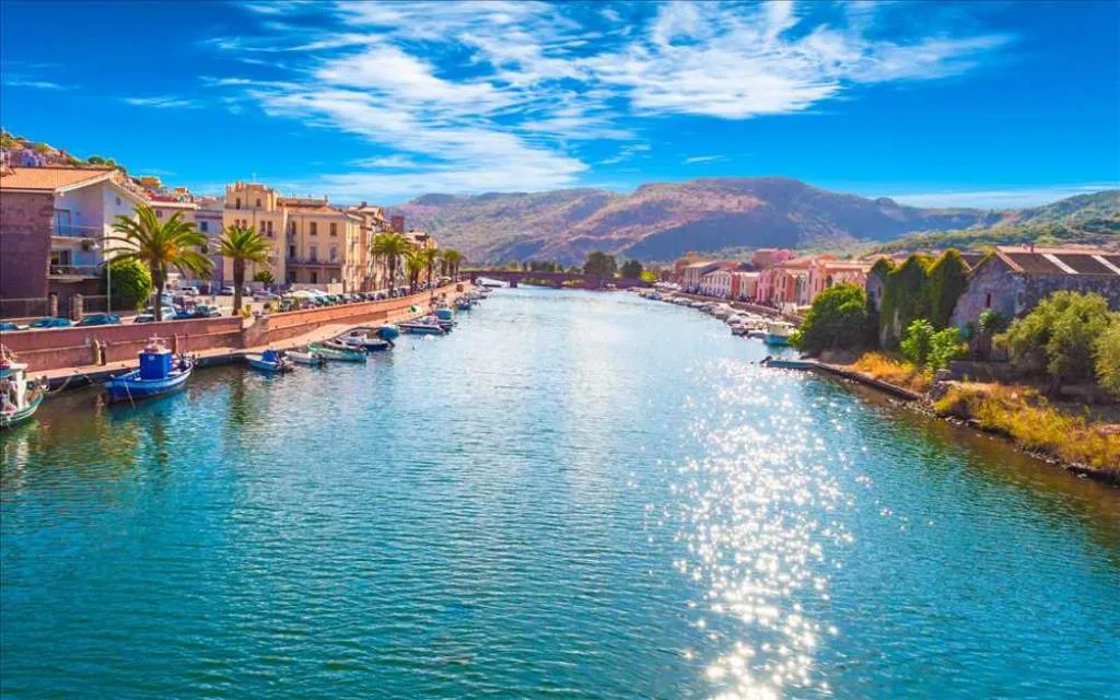 Fiume di Bosa con barche, palme e colline sullo sfondo