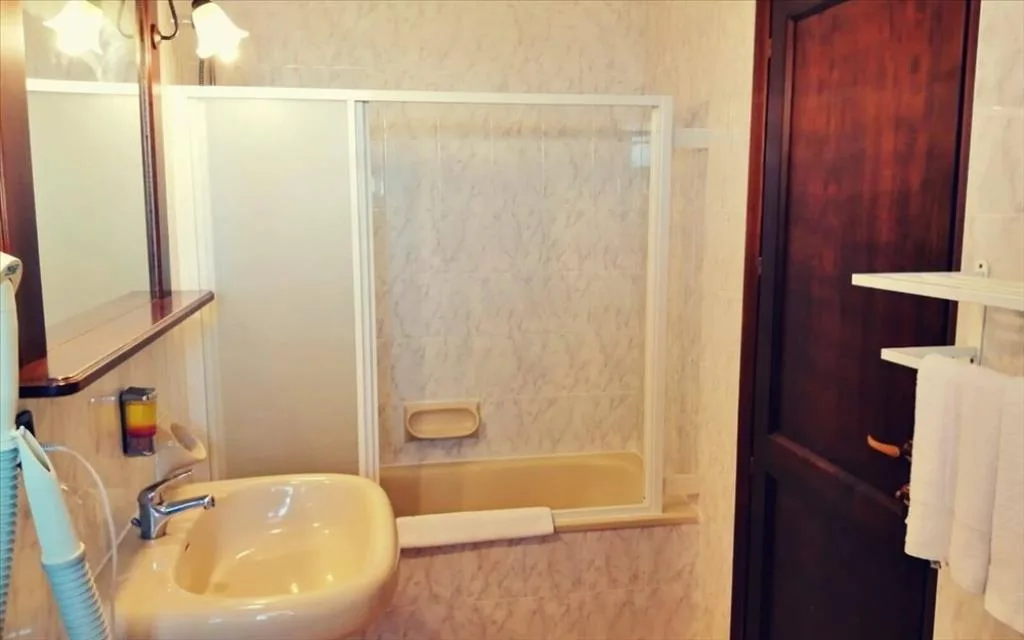 Bagno con lavandino, specchio e vasca con porta scorrevole