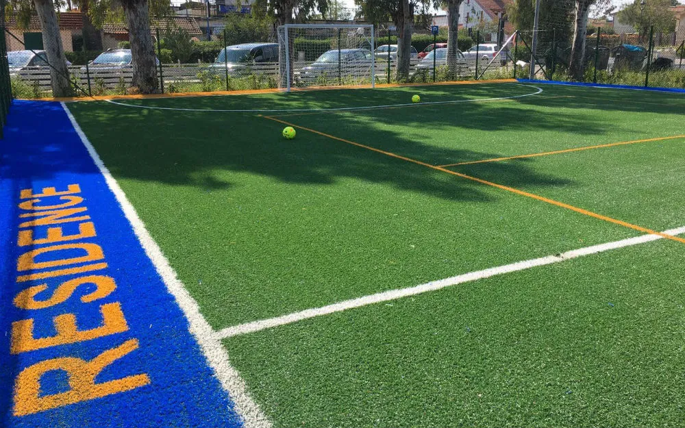 Campo sportivo in erba sintetica con scritta Residence e palloni