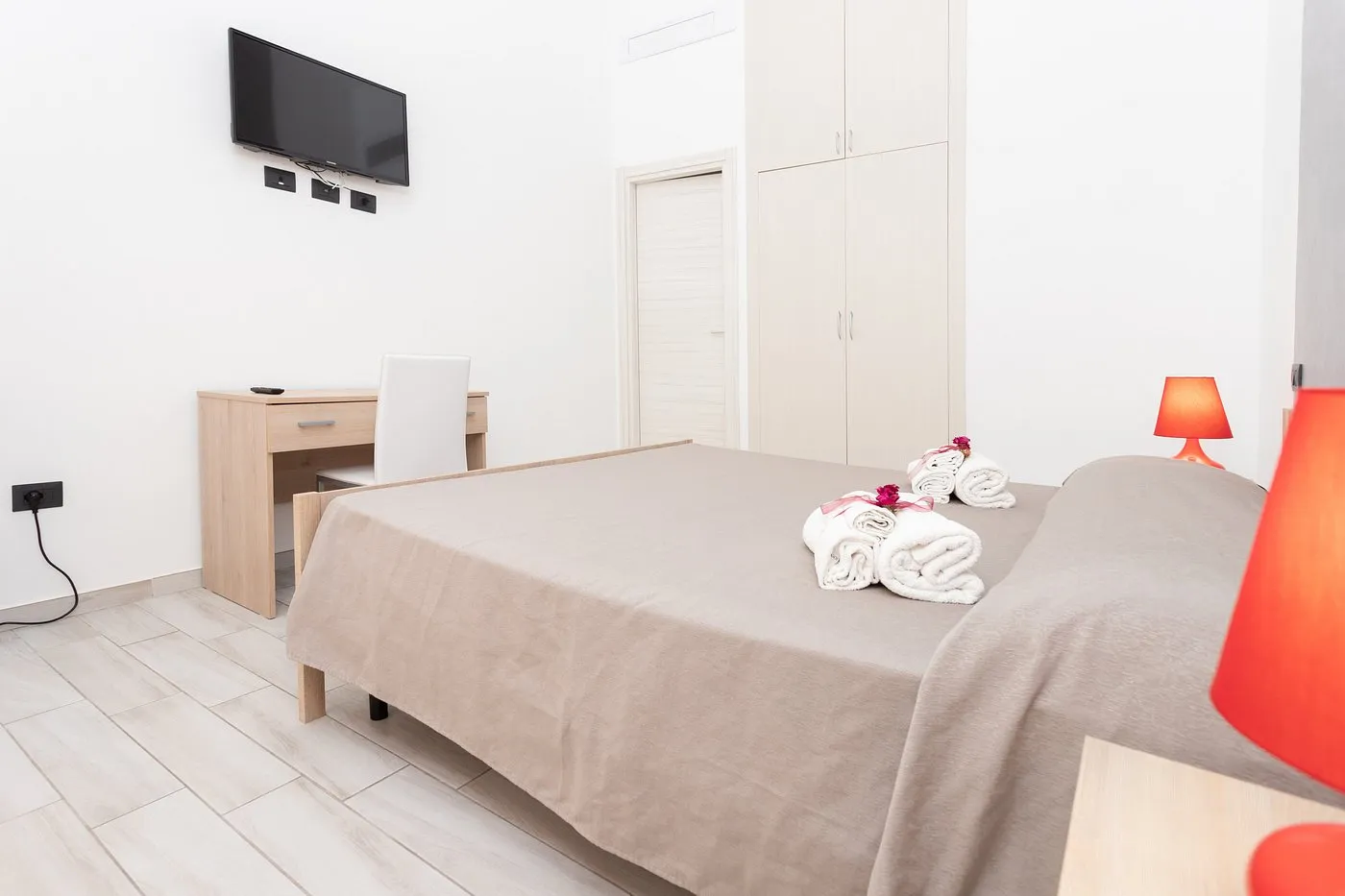 Camera moderna con letto matrimoniale, TV a parete e scrivania