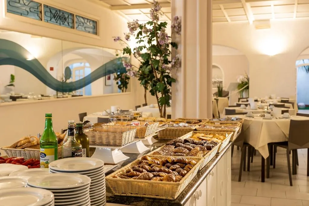 Buffet di colazione con pane, dolci e bevande nella sala da pranzo