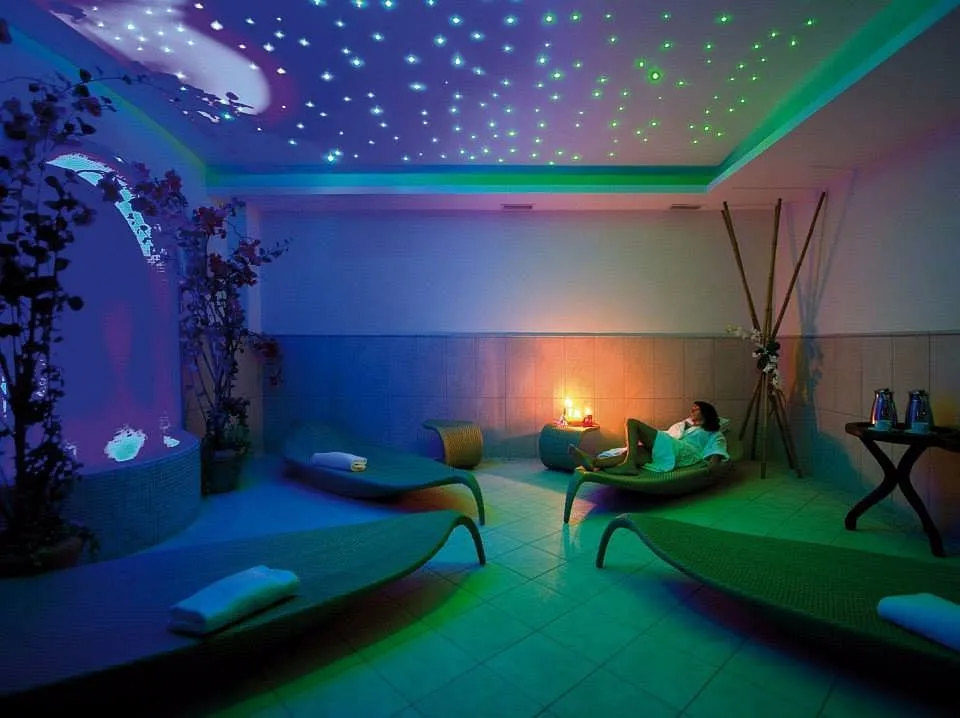 Area relax della spa con lettini, soffitto stellato e illuminazione colorata