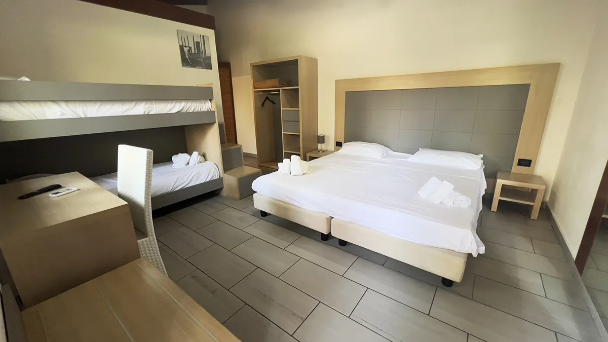 Camera familiare con letto matrimoniale, letto a castello e armadio aperto