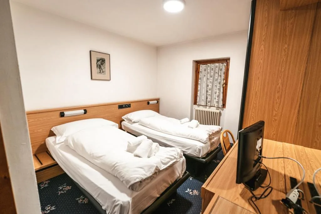 Camera con due letti singoli, finestra e TV
