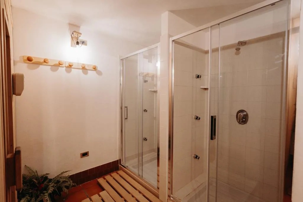 Area docce della spa con cabine in vetro e pedana in legno