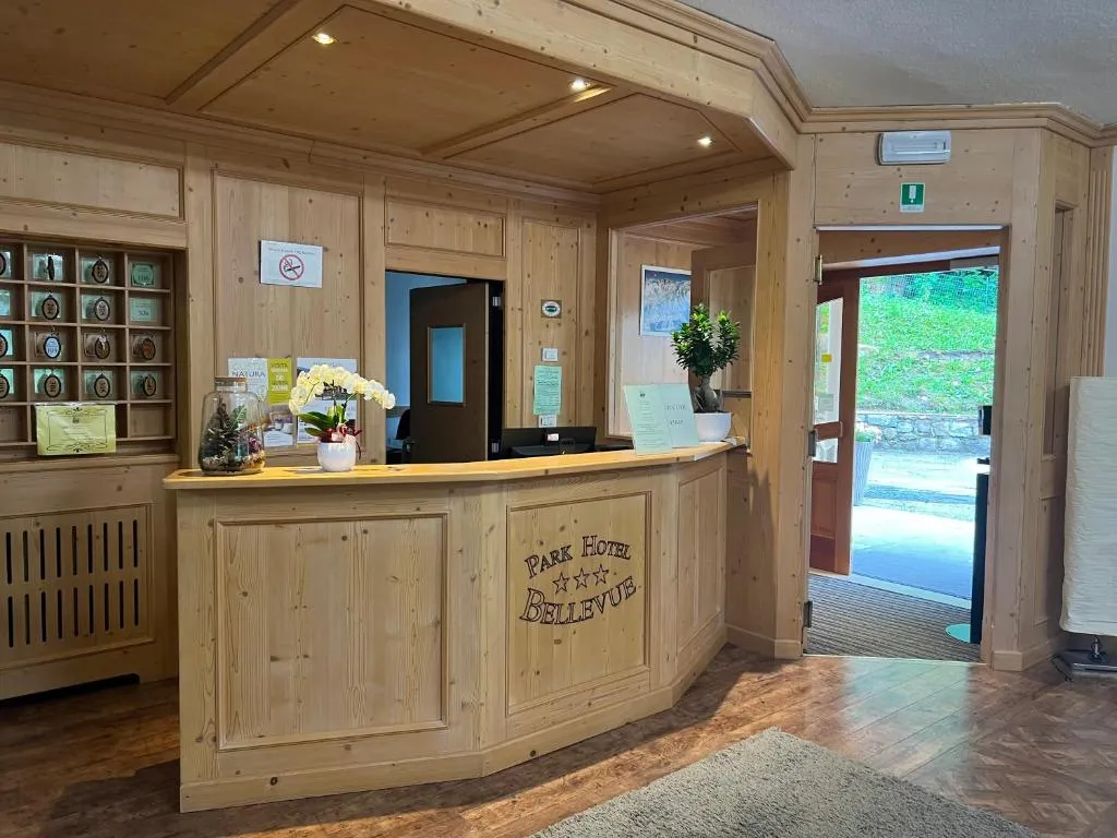 Reception dell'hotel rivestita in legno chiaro con insegna Park Hotel Bellevue