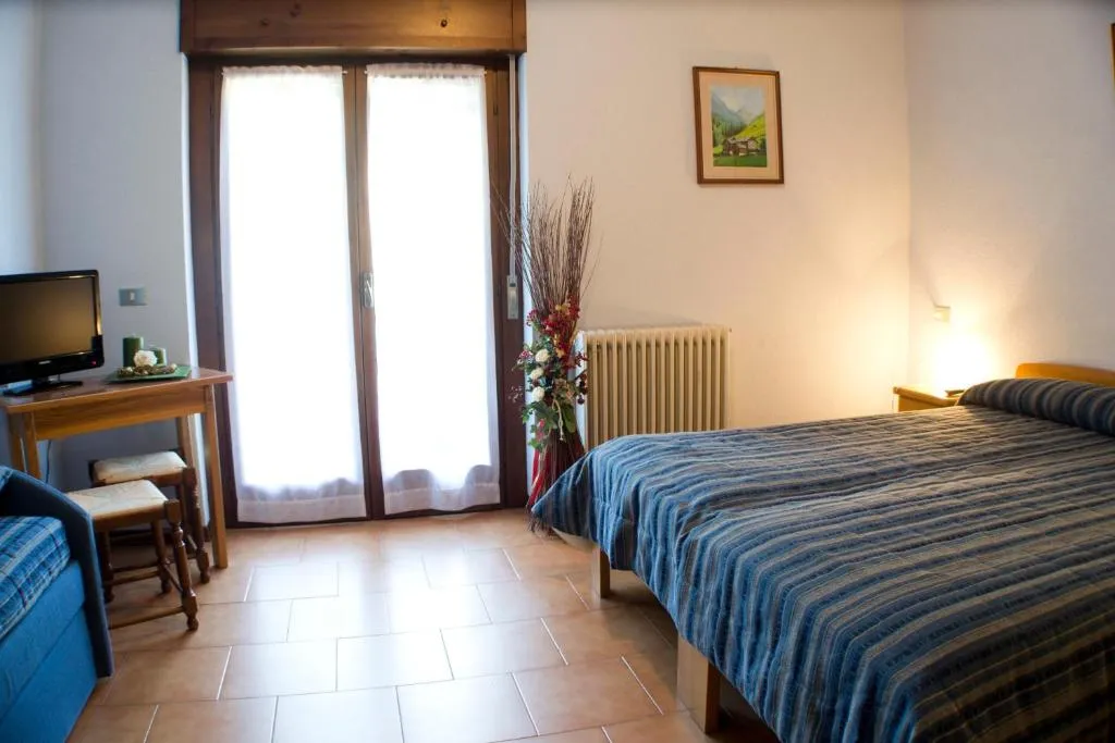 Camera con letto matrimoniale, scrivania, TV e copriletto a righe blu