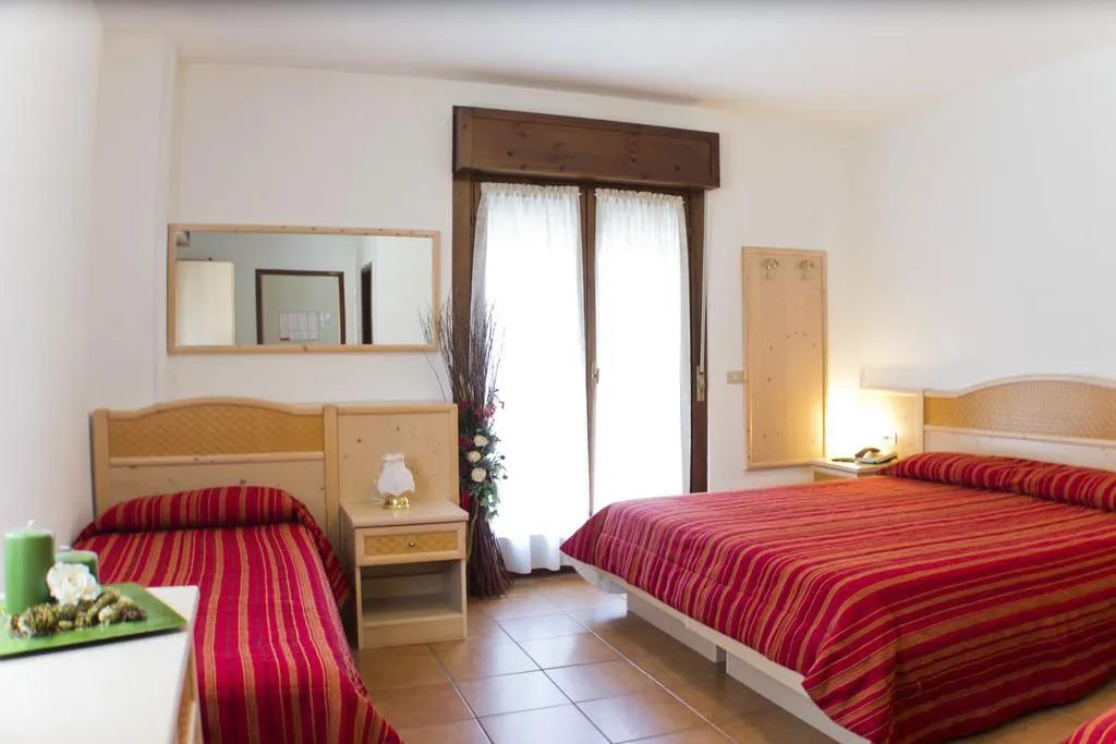 Camera con letto matrimoniale e letto singolo con copriletti a righe rosse