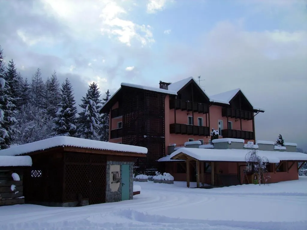 Hotel innevato con abeti carichi di neve in una giornata invernale