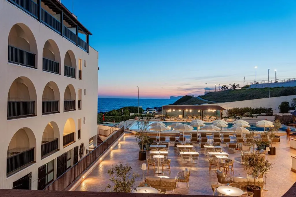 Terrazza ristorante con tavoli e ombrelloni vicino alla piscina al tramonto