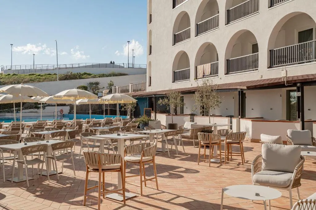 Terrazza ristorante esterna con tavoli e sedie vicino alla piscina
