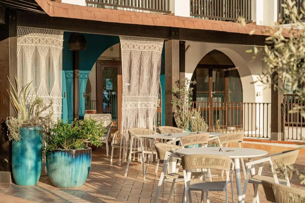 Terrazza esterna con tavoli, sedie e tende decorative in macramè