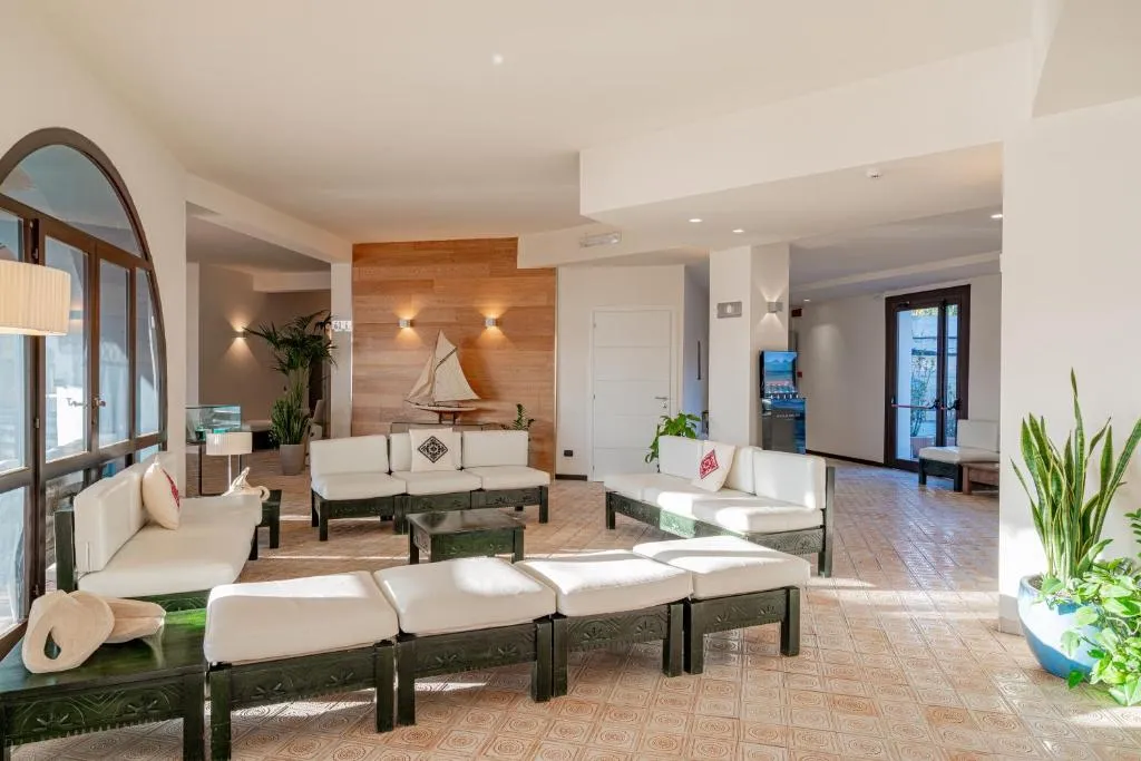 Hall dell'hotel con divani bianchi, piante e decorazioni nautiche