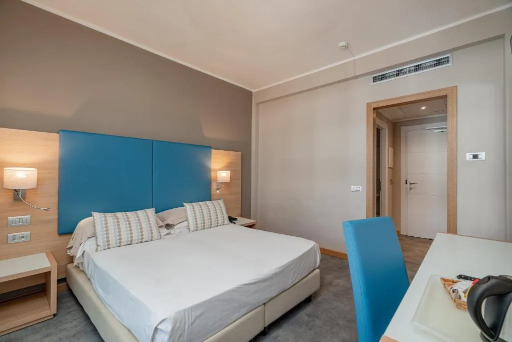 Camera matrimoniale con testiera azzurra e scrivania