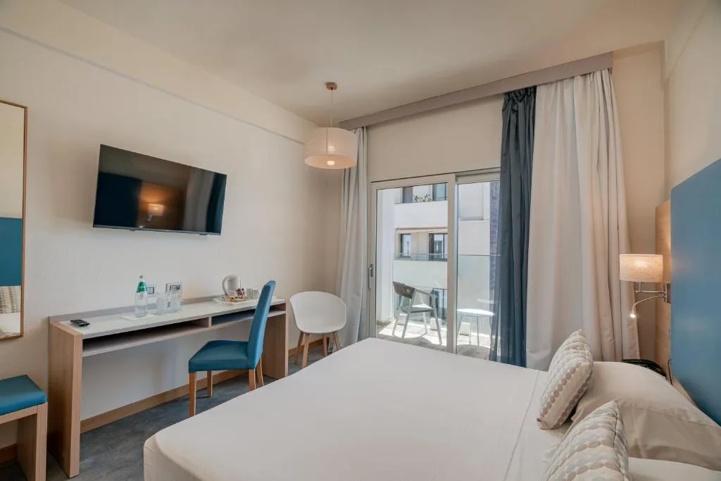 Camera con letto matrimoniale, scrivania, TV e balcone