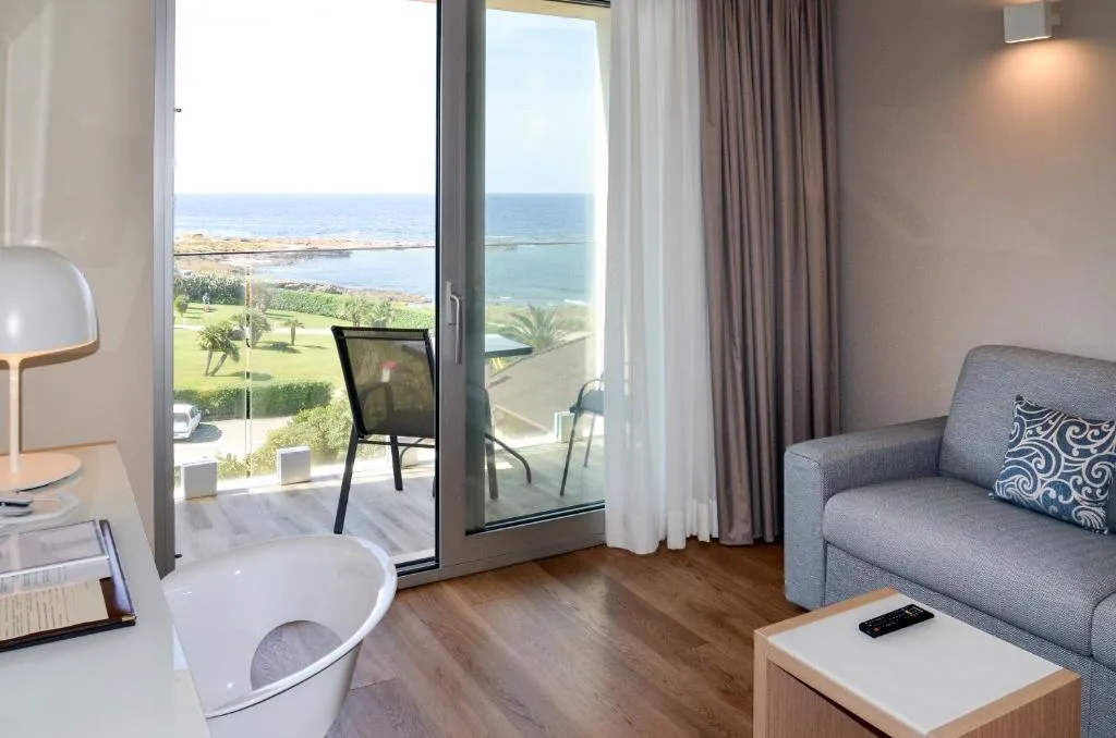 Zona soggiorno della camera con divano e vista mare dalla finestra