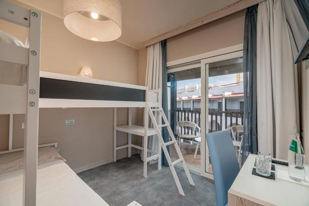 Camera con letti a castello, scrivania e accesso al balcone
