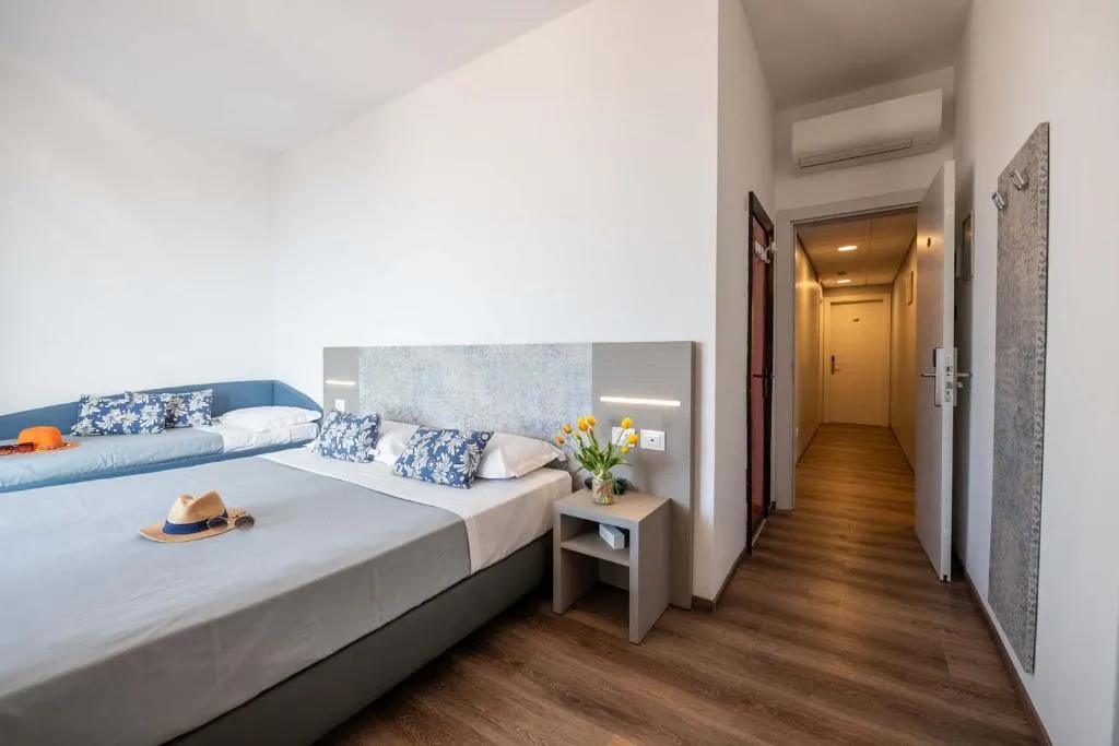 Camera con letto matrimoniale, cuscini decorativi e corridoio interno
