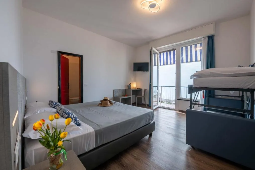 Camera familiare con letto matrimoniale, letto a castello e balcone vista mare