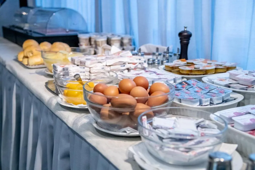 Buffet della colazione con uova, yogurt, marmellate e dolci