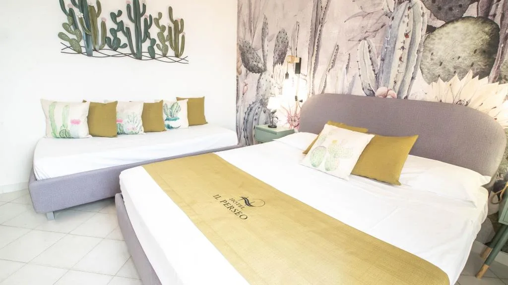 Camera con decorazioni di cactus, letto matrimoniale e letto singolo con cuscini gialli