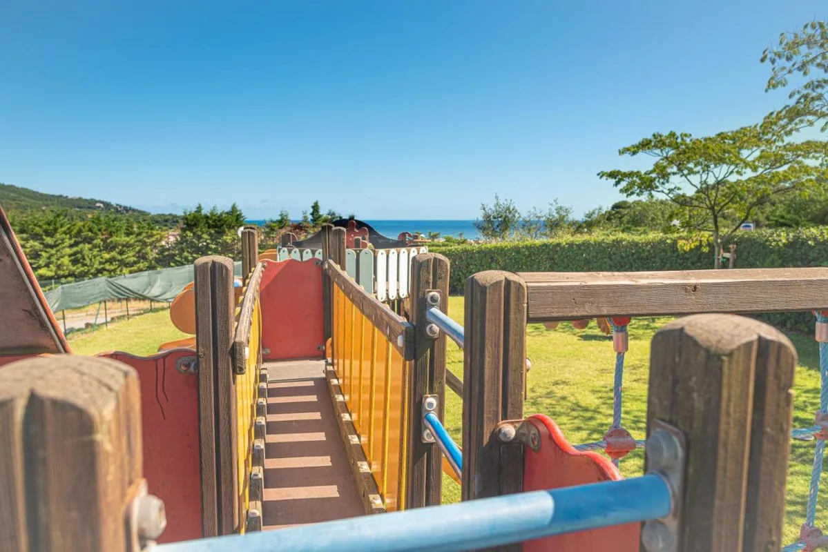 Gioco a forma di nave per bambini con vista sul mare e sulla vegetazione