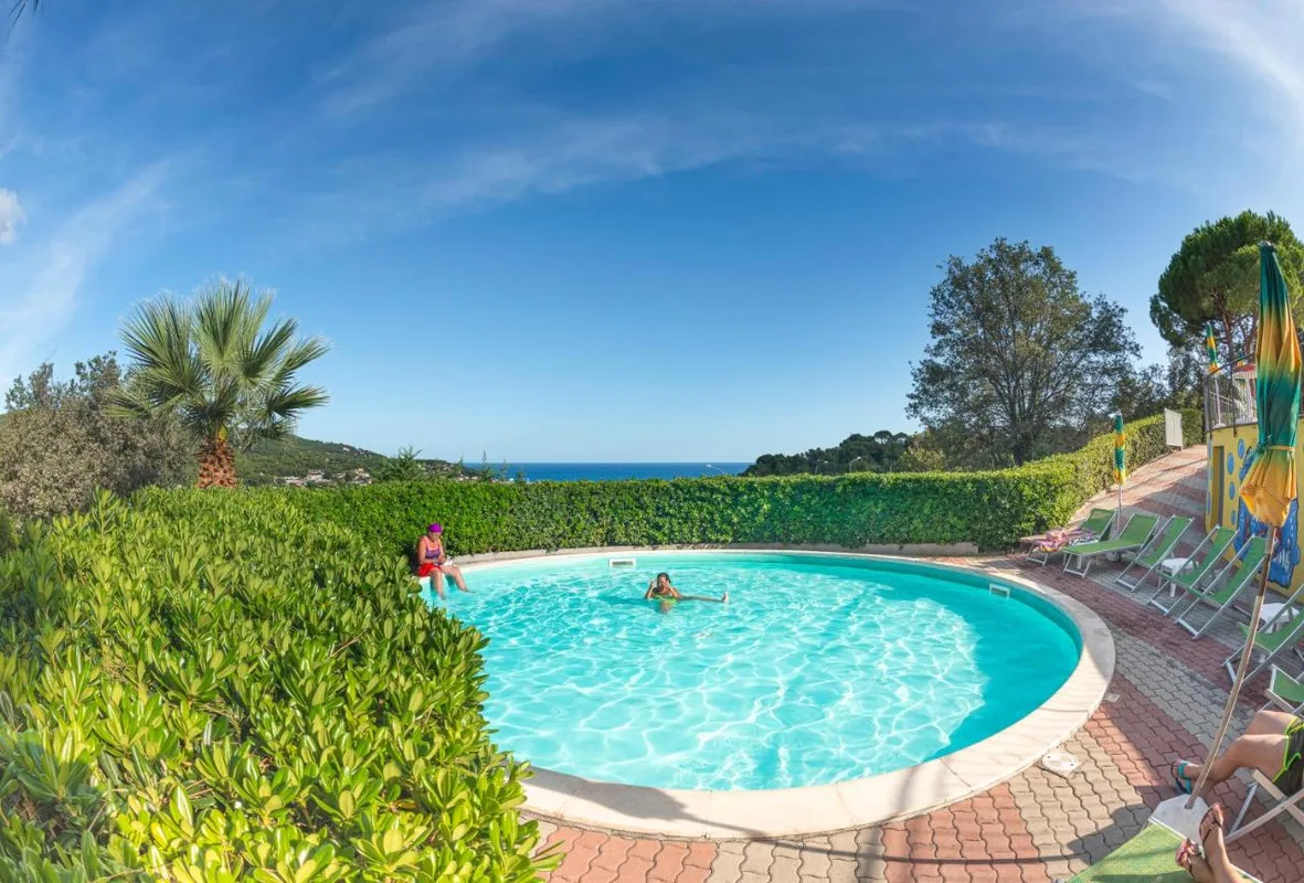 Piscina circolare immersa nel verde con vista panoramica sul mare