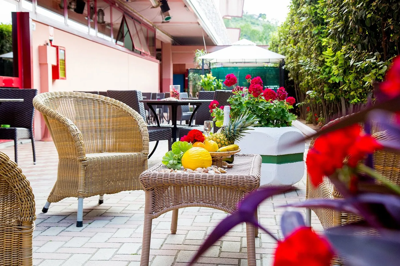 Hall dell'hotel con poltrone chiare, tavolino in legno e televisore a parete