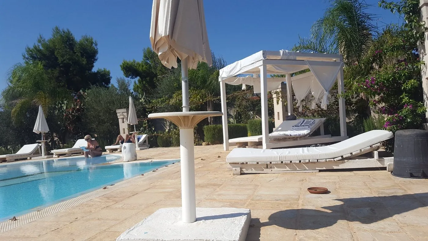 Bordo piscina con lettini, gazebo e ombrellone