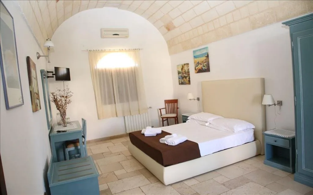 Camera con soffitto a volta in pietra, scrivania e TV