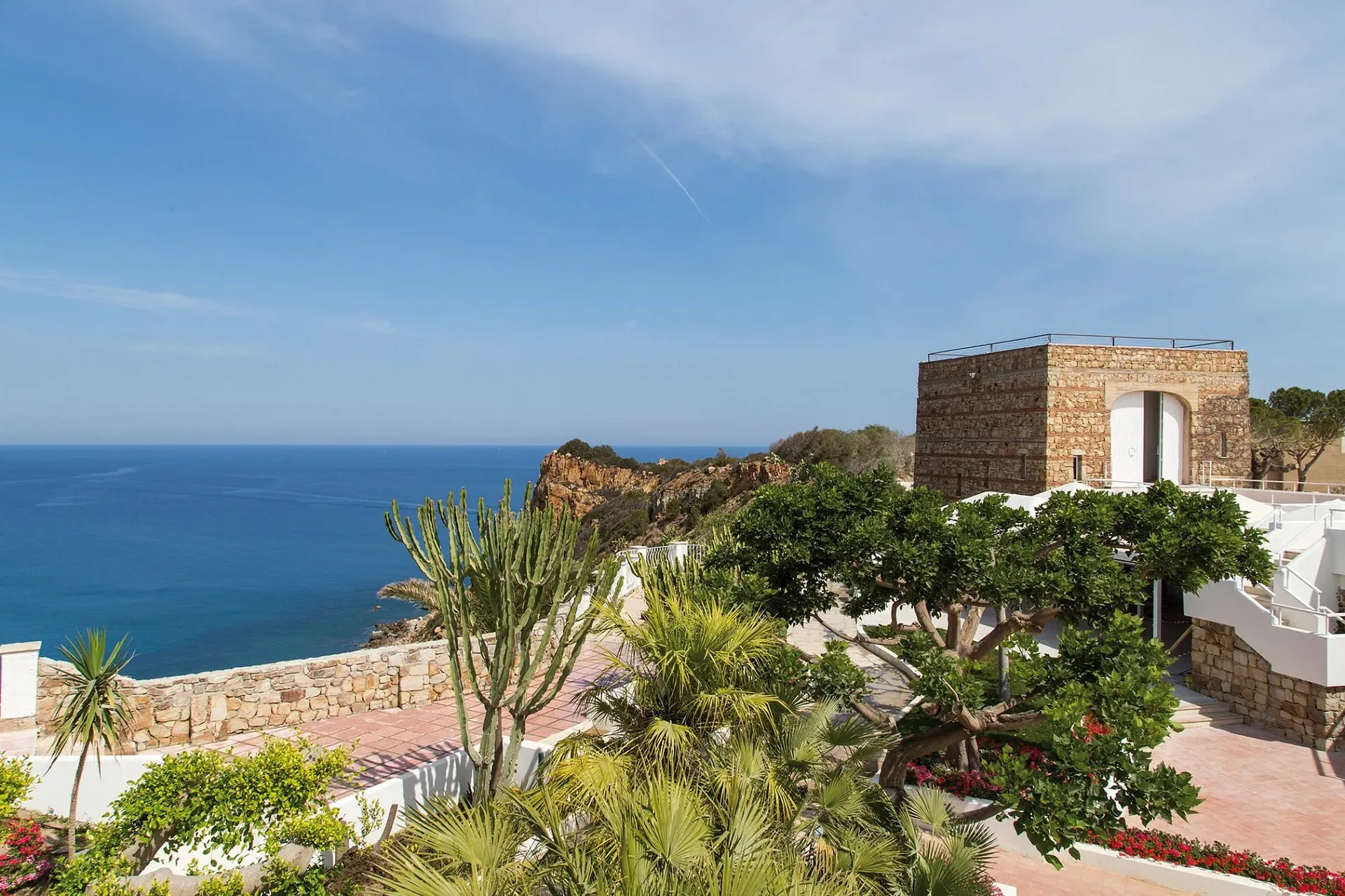 Terrazza panoramica con torre in pietra, giardino e vista mare