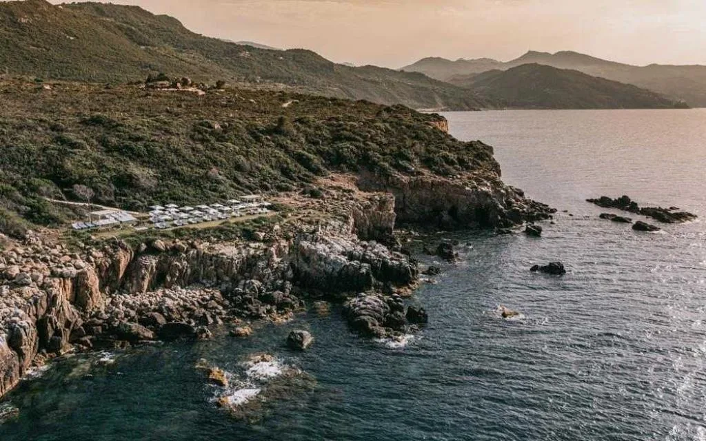 Veduta aerea della costa rocciosa con solarium del resort al tramonto