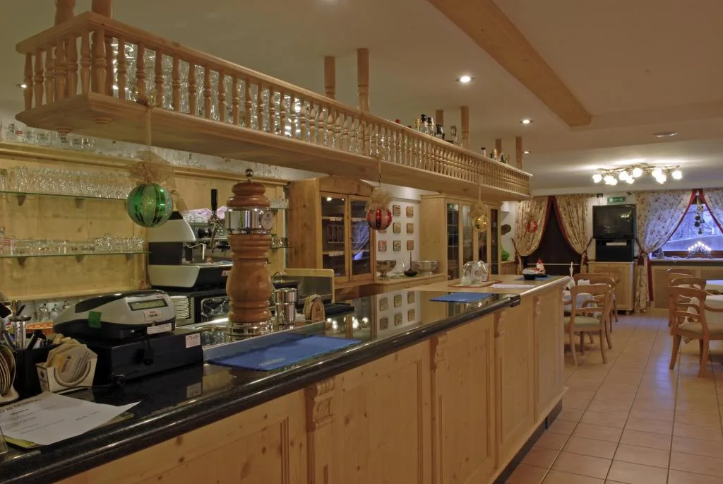 Bancone bar in legno con macchina del caffè e ambiente accogliente