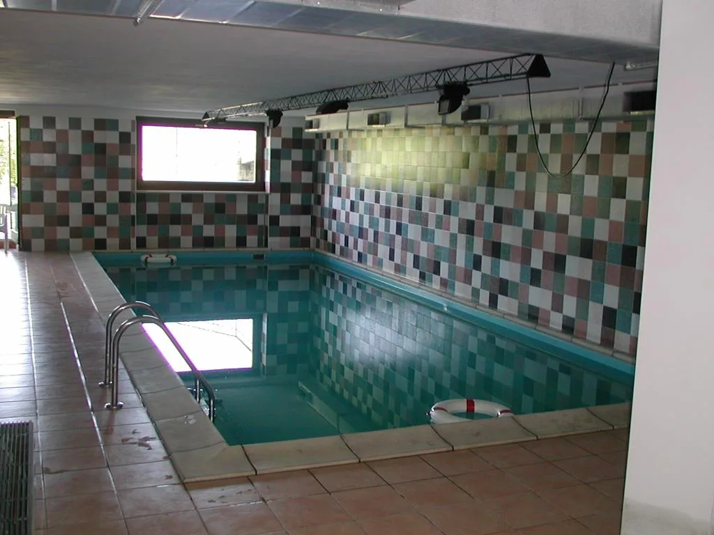 Piscina coperta con pareti a mosaico colorato e salvagente