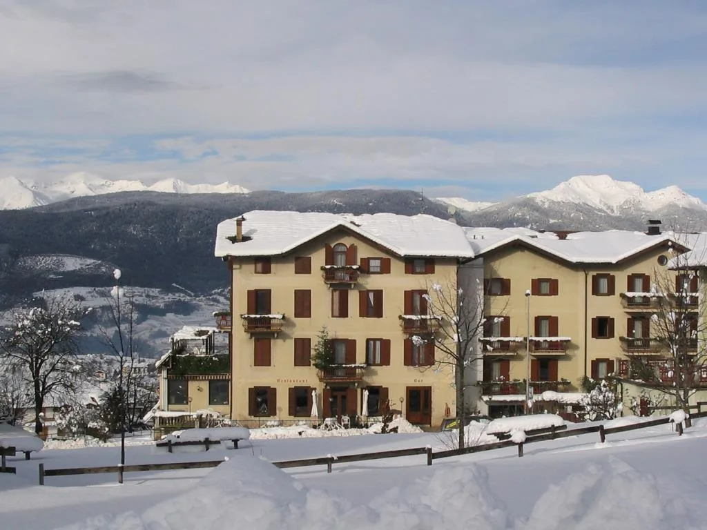 Vista invernale dell'hotel innevato con montagne sullo sfondo