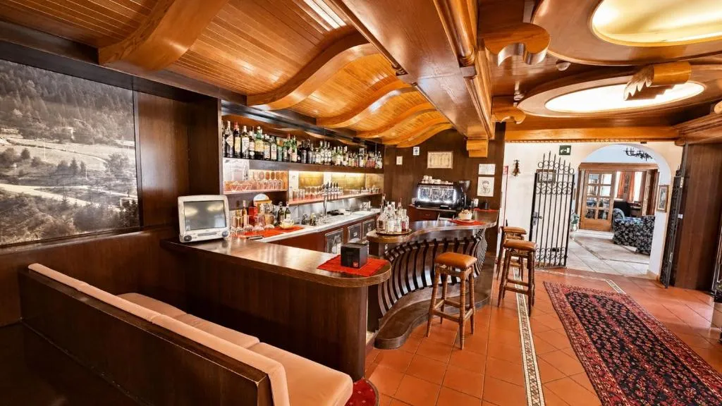 Bar dell'hotel con bancone e soffitto in legno lavorato e tappeto orientale