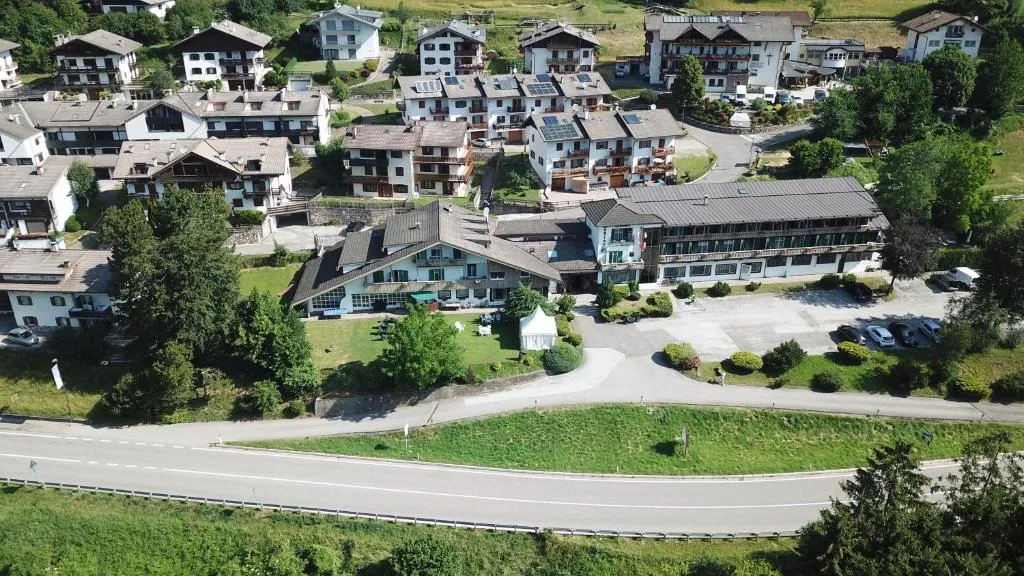 Veduta aerea dell'hotel immerso nel villaggio alpino circondato dal verde