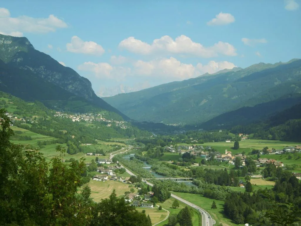 Panorama della valle alpina con villaggi, fiume e montagne